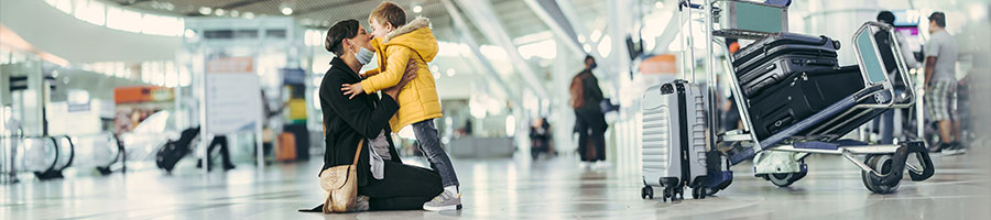 woman greets her young son in an airport terminal