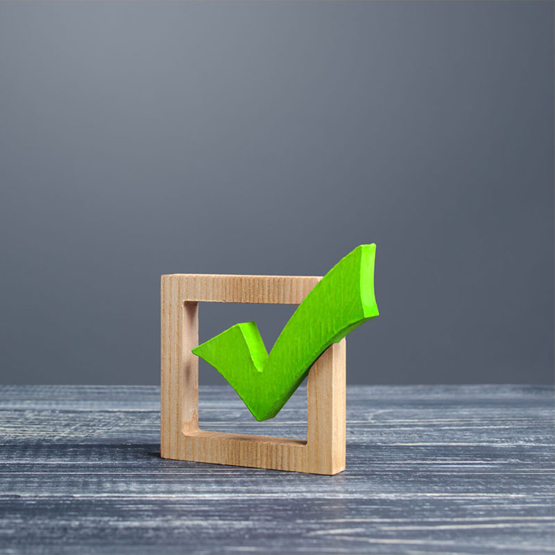 a wooden box with a green check mark