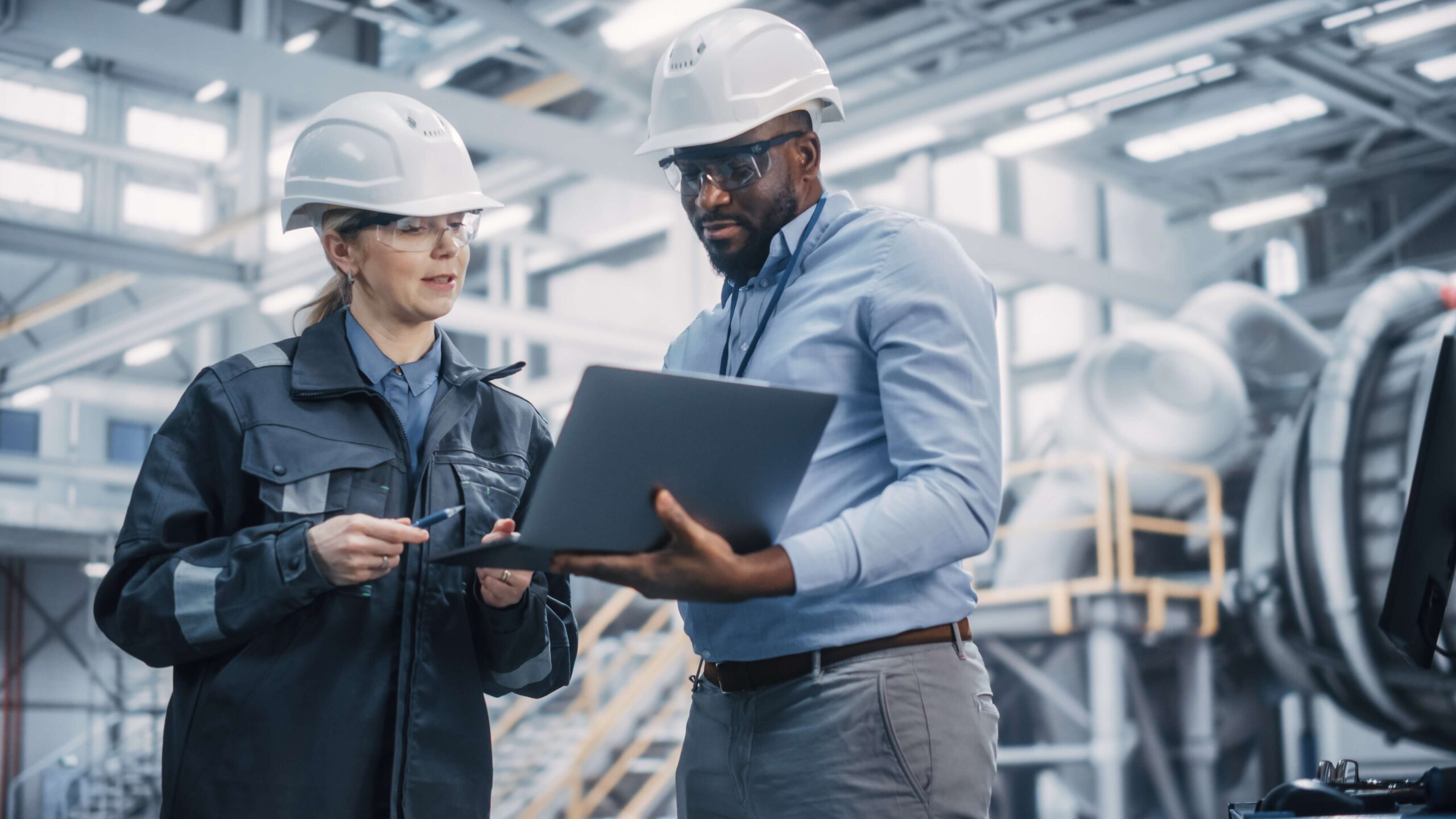 Facility services resources: a facility manager reviewing operations data on a laptop at a production site