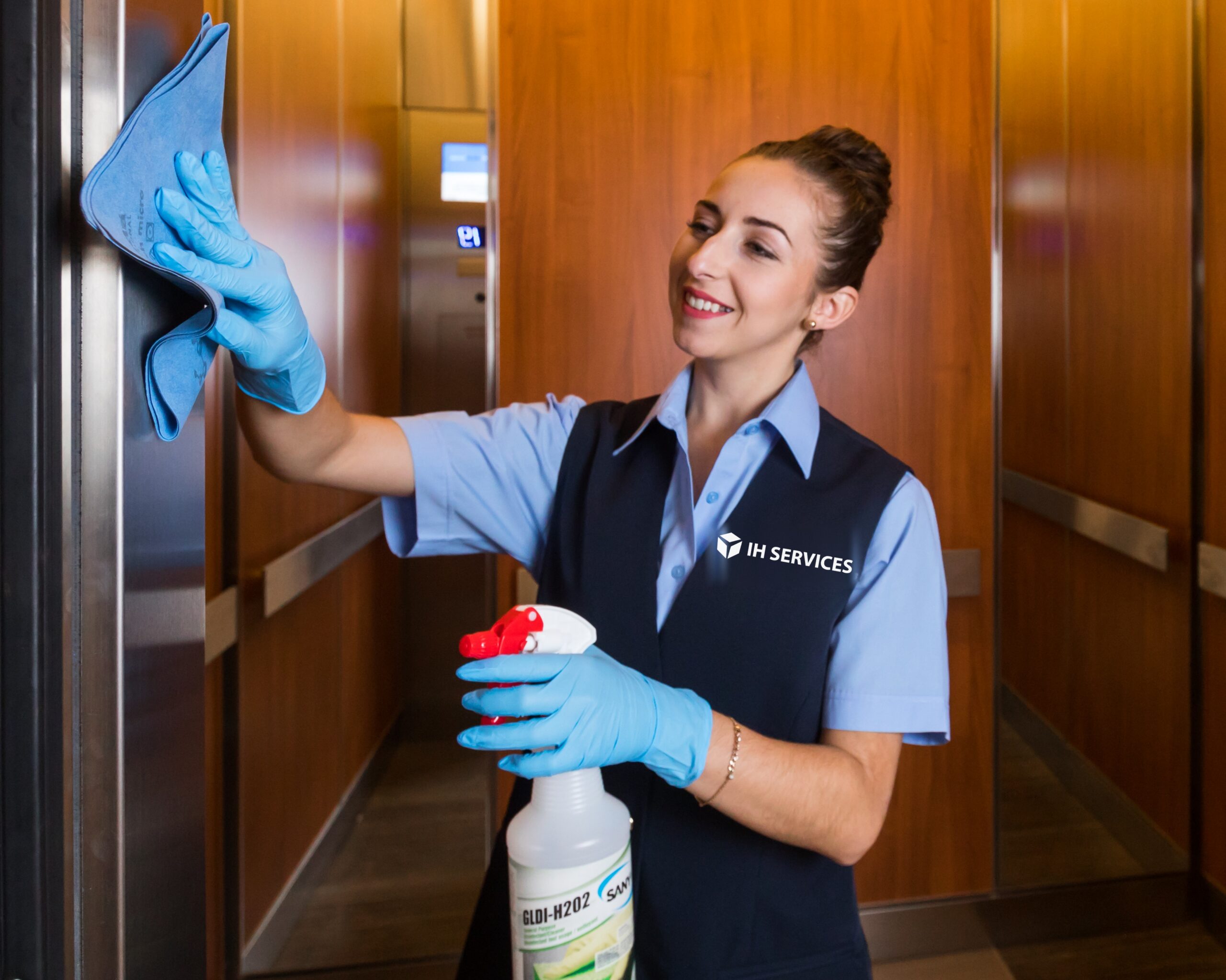 Cleared IH Services custodian cleaning an elevator cab