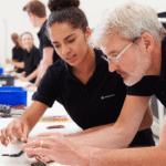 IH Services technicians inspecting equipment together on a workbench